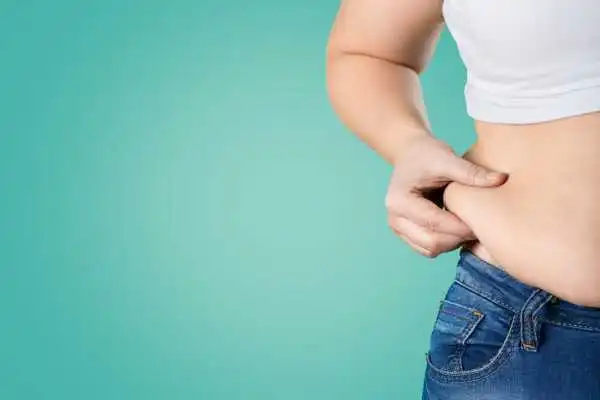 Image of woman pinching her love handles to show weight gain Southall